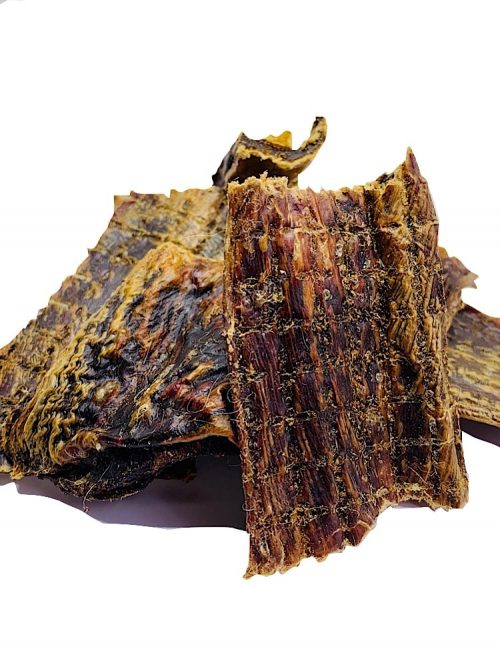 Photograph of 5 or 6 dried pieces of kangaroo jerky in a pile on a white background