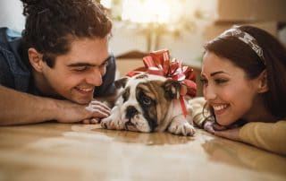 Smiling Young Couple Enjoying With a puppy